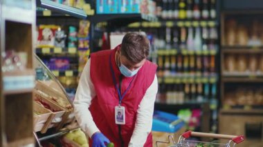 Süpermarkette meyve hokkabazlığı yapan komik, genç satıcı. Güzel, taze, perakende satış mağazası yavaş çekim.