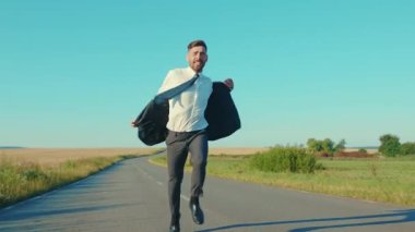 Başarılı bir iş adamı, buğday tarlası özgürlük kavramının yakınındaki ceketli kır yolunu kaldırır. Yakışıklı galip, zarif ağır çekimde zıplar.