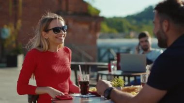 Portre, rahatlatıcı erkek ve kadın kokteyl içerken sokak kafesinde birlikte yemek yiyor kız arkadaş, neşeli, ağır çekimde portre yiyor.