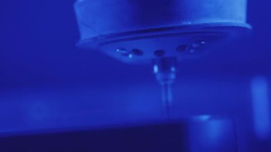 Mavi ışık teknisyen dişçi inşaatında diş değirmeni makinesinden insan dişi şekillendirme işleminin diş fırçası çalışmalarını kapatın.