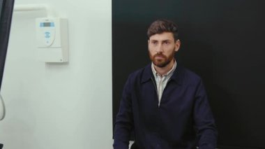 Oturan genç yakışıklı adam, bak. Diş hekiminin dişçisinde fotoğraf çekiyor. Tıp kürsüsünde, klinik bakımı kliniğinde.