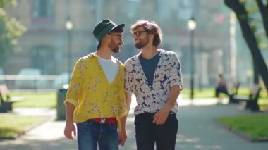 Kapalı kapılar ardında yürüyen iki eşcinsel el ele tutuşup birbirlerine bakıyorlar. Eşcinsel çiftler, LGBT ile çıkıyorlar. Açık havada gülümseyen sevgilileri seviyorlar. Yavaş çekimde çekici oluyorlar.