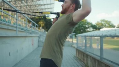 NEW YORK - 5 Eylül 2020: Trx fitness halatıyla çalışan iki genç adam stadyum Afrika kökenli Amerikan spor kıyafetleri spor kıyafetleri çekici göğüs egzersizleri yapıyor.