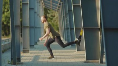 NEW YORK - 5 Eylül 2020: Trx fitness halat vücut egzersizleri ile çalışan çekici genç adam stadyum kas antrenmanlarında spor kıyafetleri spor antrenmanlarını yavaş çekim spor antrenmanlarını kapatıyor