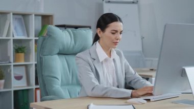 Ofiste çalışırken el kaldıran belirsiz beyaz bir kadının portresi. Emin değilim ve el işareti kullanarak da bilmiyorum. Vücut dili kavramı.