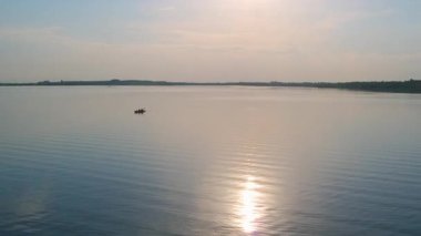 Gün batımında vahşi ve huzurlu nehir manzarası. Güzel manzaralı sakin su ve sahil şeridi. Huzurlu bir manzara. Yaz tatili.
