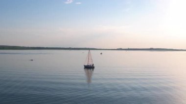Muhteşem manzaralı nehir manzarasının havadan çekimi. Huzurlu sularda yüzen küçük bir yat. Idyllic doğa, eko çevre ve eğlence.
