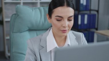 Bilgisayarın önünde zarif takım elbiseli, zeki, beyaz iş kadınının portresi. Ofisteki monitöre bakan sevimli bir kadın. Teknoloji, kapalı alanda. Avukat.