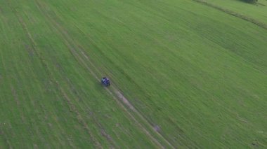 Sonsuz kırsal arazinin havadan çekilmiş görüntüsü. Bahçede bisiklet süren turistler kırsal yeşil çayır boyunca araba sürüyorlar. Turizm, seyahat, aşırı uçlar ve duygular. İHA uçuşu.
