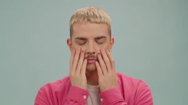 Ciddi eşcinsel adam kameraya bakar boyalı gökkuşağı Lgbt bayrağıyla el ele tutuşur