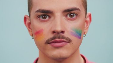 Yaklaş genç eşcinsel adam kameraya bakıyor gülümseyen gökkuşağı boyası Lgbt bayrağı yüzü