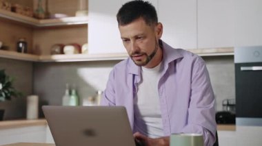 Kasların gerilmesinden muzdarip, bilgisayarın aşırı çalışmasından dolayı acı çeken kaslı, beyaz, stresli genç bir adamın görüntüsü. Yorgun çalışanın portresi görevlerle dolup taşıyor. Uzak çalışma