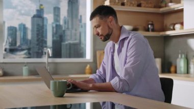 Genç sakallı, ciddi bir adam evin mutfağında dizüstü bilgisayarda yazı yazıyor. Sinirli patron görüntüsü. Çalışanları kontrol ediyor, arıyor. Duygusal konuşmalar. Takım. Uzaktan kumanda. Kapalı