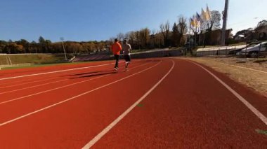 Genç Kafkas takım sporları futbol sahasında yoğun kardiyo antrenmanı yapıyorlar. Koşucu çift. Maraton. Açık hava egzersizi..