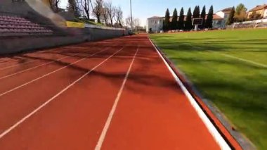 Futbol sahasında havadan FPV uçuşu. Egzersiz yapmadan önce birkaç koşucu dışarıda antrenman yapıyor. Sağlıklı yaşam tarzını kabul et.