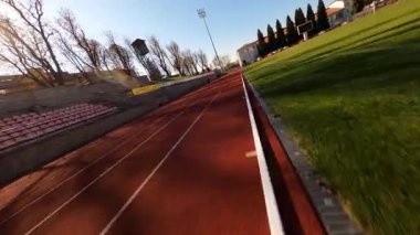 Stadyumda iki genç sporcu kardiyo çalışması yapıyor. Koşu antrenmanına hazırlanan iki erkek ve kadın fitness çalışanı. FPV konsepti.