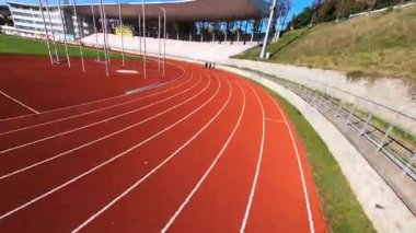 Stadyum üzerinde manevra yapabilen FPV insansız hava aracı uçuşu. Çağdaş büyük futbol sahası ve koşu pisti. Spor salonu. İnşaat. Hava görünümleri.