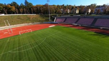 Sinematik FPV hava manzaralı geniş profesyonel futbol sahası spor stadyumu eğitimli insanlar. Manevra yapılabilir uçuş.