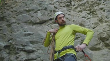 Tırmanmak için güvenlik ekipmanı ve kask takan genç bir sporcu. Ormanda yürüyüş yapan biri. Dağ tırmanışı. Aktivite. Rekreasyon.