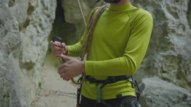 Ormanda dağ tırmanışı yapan bir adam. Yakışıklı, yakışıklı, dağcı, Cliff 'te ekipman ayarlıyor. Yürüyüş aktivitesi. Yaz tatili.