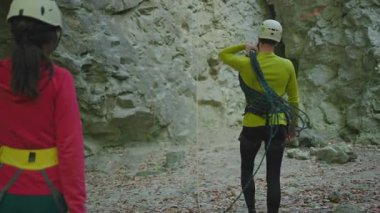 Kafkasyalı genç aktif yürüyüş yapan kadın dağcılar güvenlik kaskı takıyor tırmanma faaliyetleri için halat taşıyorlar. Dağlarda yürüyüş. Yaz tatili.