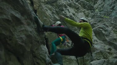 Beyaz tenli birkaç erkek sporcu dikkatle tırmanıyor ve dağlara tırmanıyor. Dağcı. Dağcılar. İlişki. Tatil.