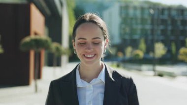 Akıllı telefonu elinde tutan, konuşan, arayan sevimli, arkadaş canlısı, beyaz bir kadının yakın plan fotoğrafı. Neşeli kız etrafa bakıyor. Yürü, gündüz vakti. Güneşli bir gün. Yaz zamanı. Mobil, teknoloji