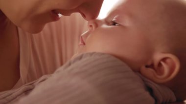 Kafkas bebek ve anne portresi. Odasında yeni doğmuş güzel bir anneyle çekilmiş bir fotoğraf. Daire. Ebeveynlik, şefkat. - Aile. Çocuğun ve annenin burunlarına dokunduğu bir sahne. Şefkat, aşk