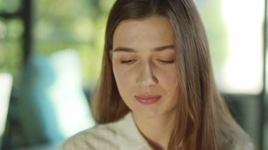 Çekici bir genç kadının portresi başını çeviriyor ve güneş ışığı ofisinde kameraya ciddi ciddi bakıyor. Başarılı bir iş kadını. Motive olmuş bir işveren. İşçiye konsantre ol. Yavaş çekim