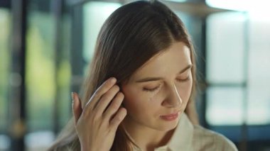 Çekici, mutlu, güzel genç bayan, güneş ışığı ofisindeki kameraya bakmak için başını çevirir. Başarılı bir iş kadını. Motive olmuş bir işveren. Ofis çalışanı. Portre. Yavaş çekim