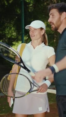 Bir erkek ve bir kadın enerjik bir şekilde tenis oynuyorlar, becerilerini ve dostluklarını sergiliyorlar, arkadaşça bir yarışmada servis ve voleybol oynuyorlar.