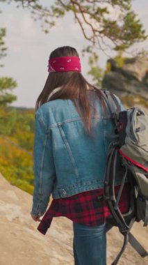 Genç bir kadın neşeyle nefes kesici manzaraları keşfediyor, eşsiz tarzını ve coşkulu ruhunu sergiliyor.