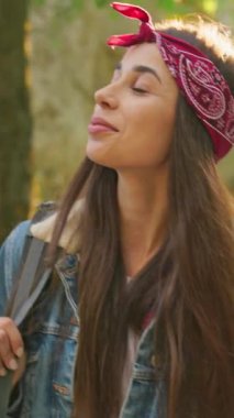 Genç bir kadın doğanın çarpıcı güzelliğinden zevk alır, şık bir şekilde bandana ve kot ceketle süslenir.