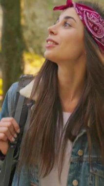 Genç bir kadın canlı bir bandana ve kot ceket giyerek lüks bir ortamda heyecan verici bir yürüyüş macerası yaşıyor.