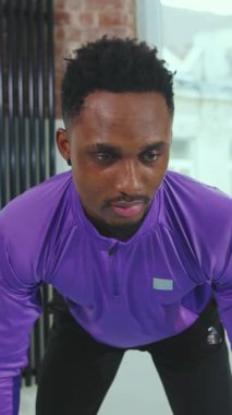 Kendini işine adamış bir sporcu şık bir spor salonunda azim ve güç gösterisi yaparak antrenmanına konsantre olur..