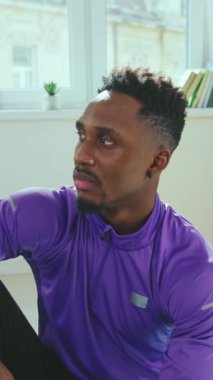 Aktif kıyafet giymiş bir adam, canlı bir fitness ortamında azmini ve odaklanmasını sergiliyor.