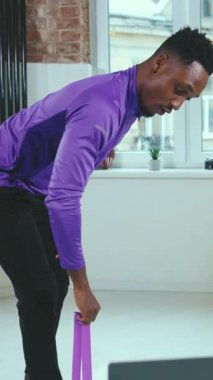 Adanmış bir birey, bacak uygunluğunu iyileştirmek ve sağlığını iyileştirmek için evde direnç bandı egzersizleri yapıyor.