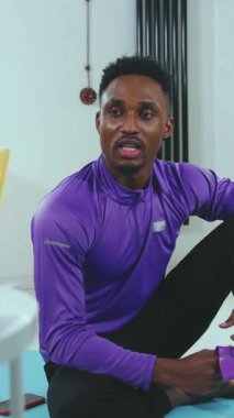 Mor giyimli bir adam coşkuyla spor ve sağlık konuları hakkında bilgi paylaşıyor.