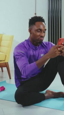 Neşeli bir adam, sağlıklı ve dengeli bir yaşam tarzını somutlaştırmak için akıllı telefonunu takip etmek için kullanır.