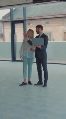 Modern bir ofis ortamında proje sezgileri hakkında kapsamlı bir tartışmaya giren iki deneyimli profesyonel