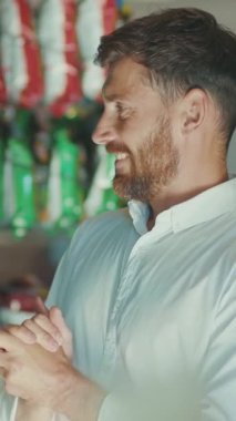 Düşünceli ve düşünceli bir adam, gündelik açık renkli bir gömlek giyiyor, sıcak ve davetkar bir çevrede düşünüyor.