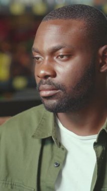 Düşünceli bir adam, tamamen rahat ve rahat bir ortamda otururken mesafeye bakıyor.