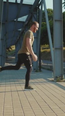 Bir adam dışarıda hamlesini yapıyor. Gücünü, direncini ve kararlılığını gösteriyor.