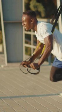 Hevesli bir birey, açık hava ortamında direniş bantları kullanarak yoğun eğitim oturumlarına katılıyor.