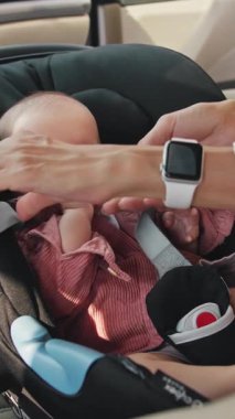 Güzel bir bebek, bebek koltuğunda huzur içinde dinleniyor, pembe bir kazak giyiyor, gezintiye çıkmaya hazır..