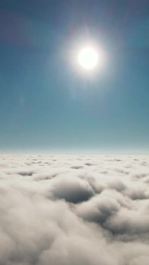 Pofuduk beyaz bulutlar denizi üzerinde parıldayan altın güneşin nefes kesici ve büyüleyici hava manzarası