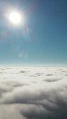 Nefes kesen bir hava manzarası altında kabarık bulutlardan oluşan engin denizi aydınlatan canlı, parlak bir güneş.