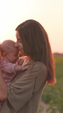 Şefkatli bir anne ile bebeğinin baş döndürücü bir gün batımında sakin bir ortamda geçirdiği hassas bir an.