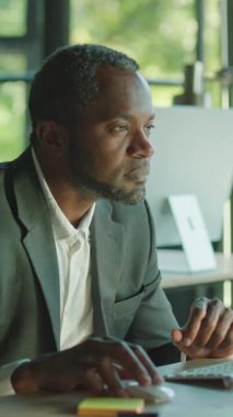 Kendini işine adamış bir profesyonel adam modern ve şık bir ofis ortamında çalışırken işine dikkatle odaklanır.