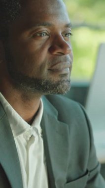 Özel dikim takım elbiseli bir beyefendi düşüncelere dalmış, sakin bir ortam yaratıyor.